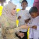 Ketua TP-PKK Kota Lhokseumawe, Ny. Yulinda Sayuti menyerahkan santunan kepada anak yatim dalam acara halalbihalal yang digelar oleh Yayasan Abulyatama Indonesia (YAI) Cabang Lhokseumawe, di Museum Kota Lhokseumawe, Minggu, 20 April 2025. (Foto: Humas Pemko)