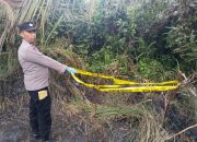 Personel kepolisian memasang garis polisi di tempat kejadian perkara (TKP)