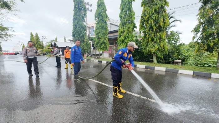 Petugas Damkar BPBD Aceh Barat, melakukan upaya pembersihan badan jalan akibat tumpahan minyak solar di ruas jalan nasional, Desa Gampong Darat, Kecamatan Johan Pahlawan, Meulaboh, Aceh Barat, Selasa (2/9/2025) sore