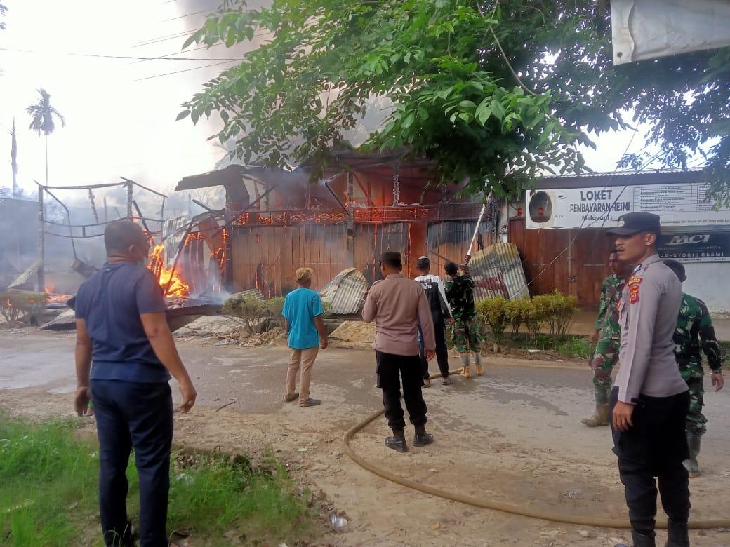 Petugas pemadam kebakaran berupaya menjinakkan si jago merah yang membakar enam unit rumah toko di Gampong Tanjong Ara, Kecamatan Tanah Jambo Aye