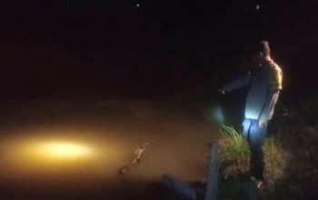 Personel kepolisian saat berada di lokasi penemuan jasad bocah yang tenggelam di saluran pembuangan, Kecamatan Baktiya, Aceh Utara