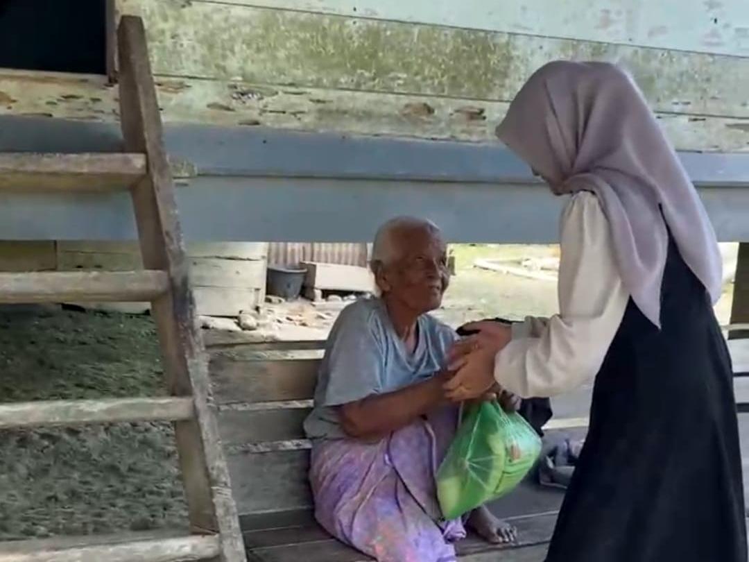 Siswi SMPN 1 Syamtalira Aron, Fatimah Zuhra (15), membagikan paket sembako dari hasil tabungannya kepada warga terdampak banjir di Aceh Utara
