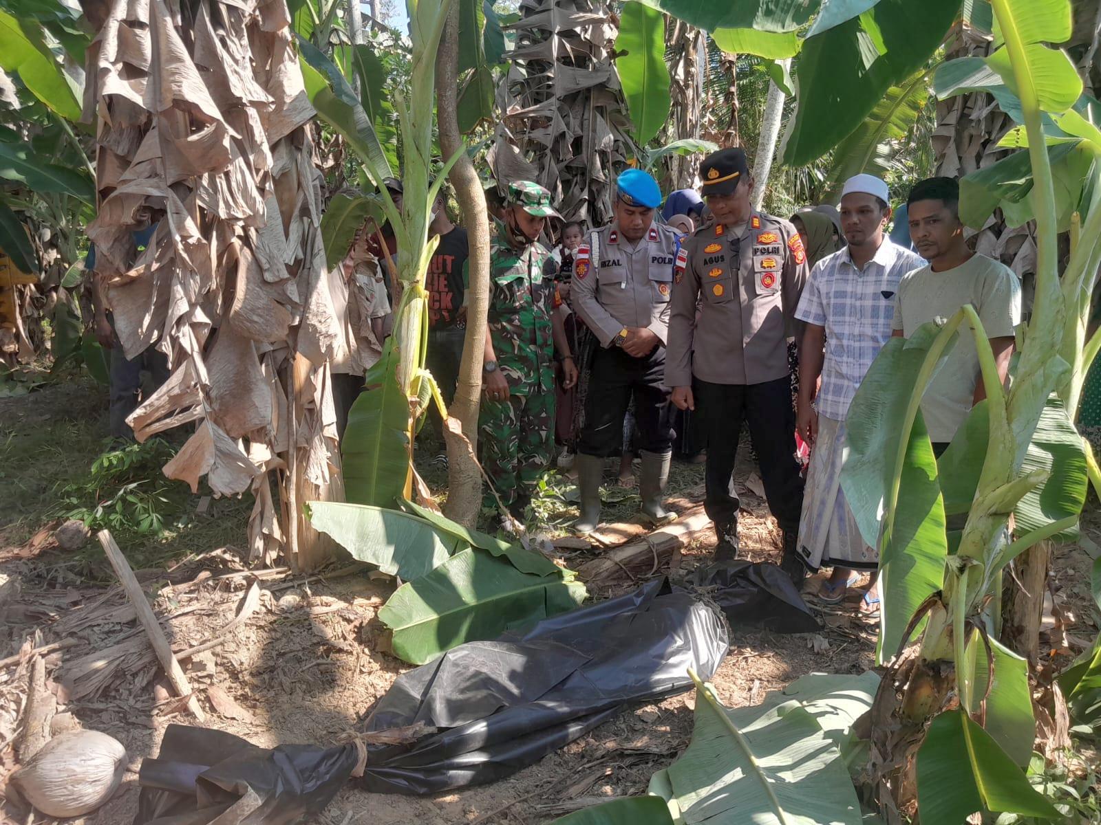 Personel Kepolisian bersama warga saat mengevakuasi jasad korban banjir yang ditemukan di bawah gundukan tanah di Gampong Biram Rayeuk, Kecamatan Tanah Jambo Aye, Aceh Utara