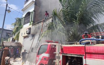 Warga membantu petugas pemadam kebakaran menjinakkan api yang menghanguskan Toko Kain Bahgia Tex di Tanah Jambo Aye, Aceh Utara