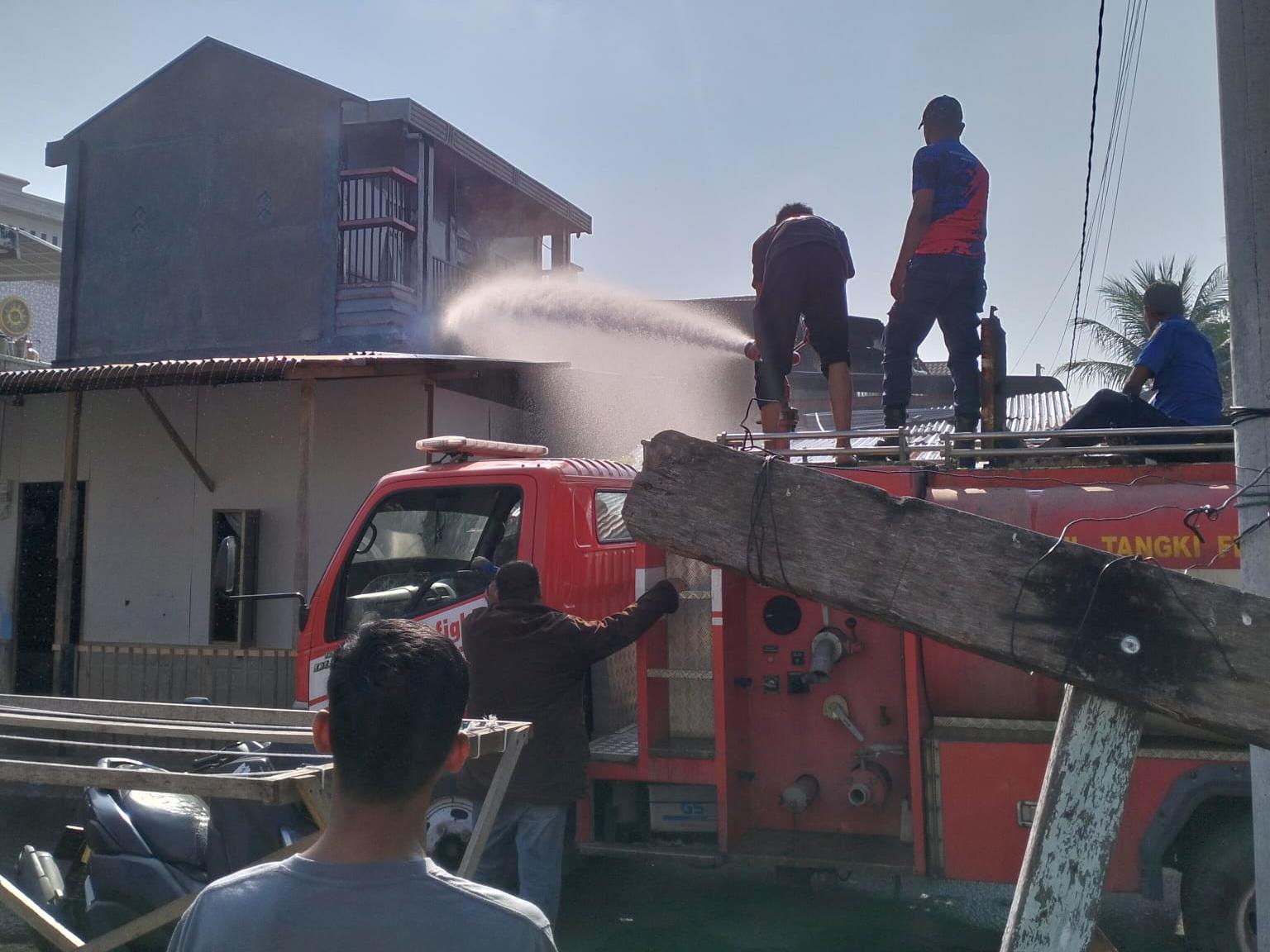 Petugas pemadam kebakaran berusaha memadamkan sisa api yang menghanguskan sebuah rumah di Desa Kampung Jawa Baru, Banda Sakti, Lhokseumawe