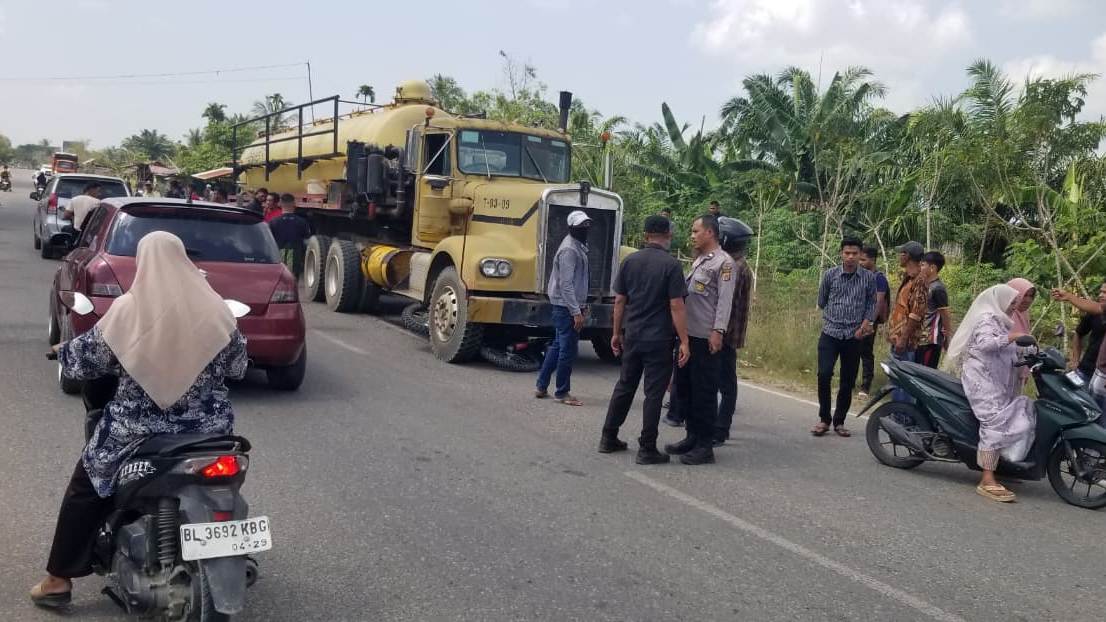 Aparat kepolisian mengamankan lokasi kecelakaan maut yang melibatkan truk vakum PT PGE dan dua sepeda motor di Gampong Rayeuk Kuta, Tanah Luas, Aceh Utara, Sabtu, 4 April 2026. Insiden tersebut menyebabkan seorang pengendara meninggal dunia.